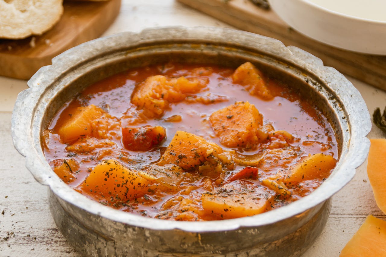 A warm and hearty rustic pumpkin soup in an ornate pot, perfect for fall dinners.