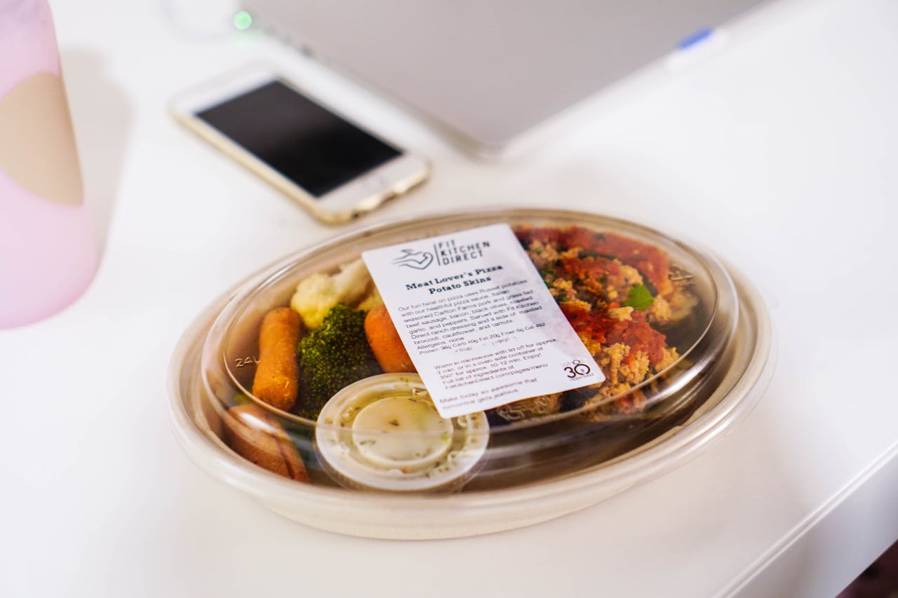A packaged meal in a plastic container featuring fresh vegetables, ideal for healthy eating concepts.